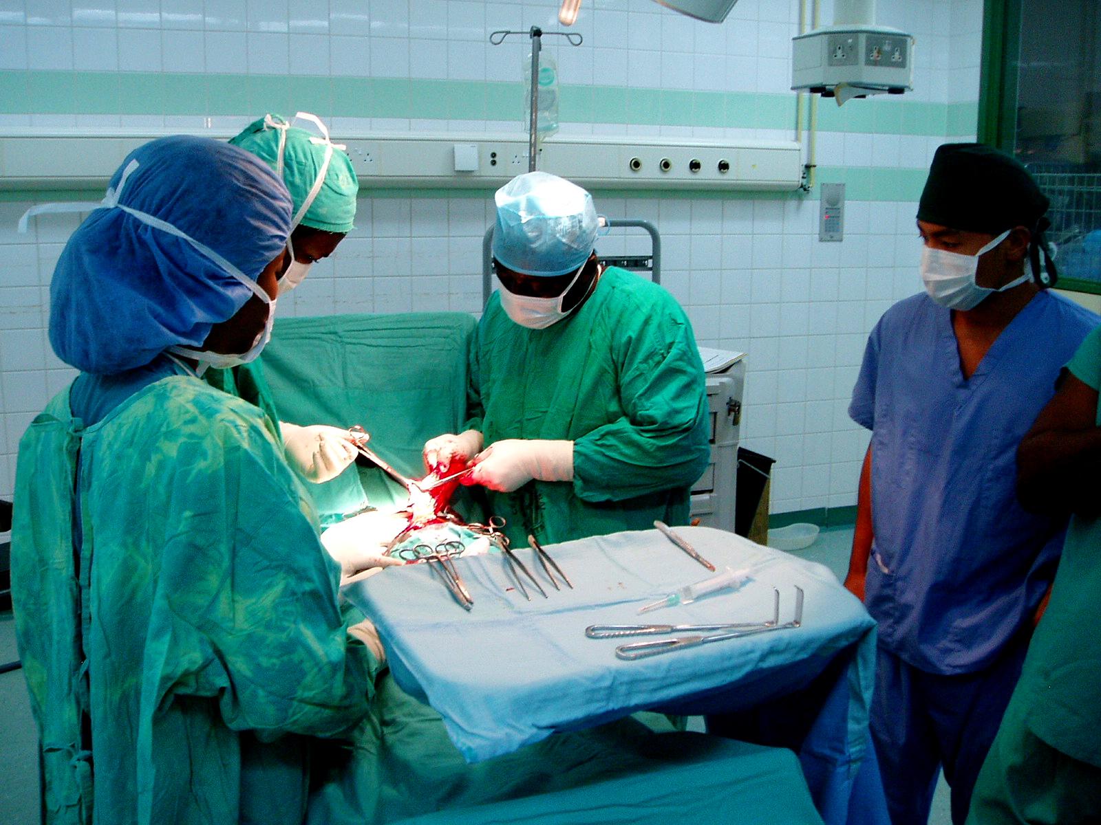 Group of Projects Abroad Medical interns observe hospital staff practising surgical precisons during Medicine internship in Ghana. Medical interns gather round local hospital staff doing a medical procedure during their Medicine placements in Ghana.